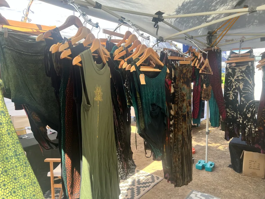 Clothing hanging on a market rack in daylight.