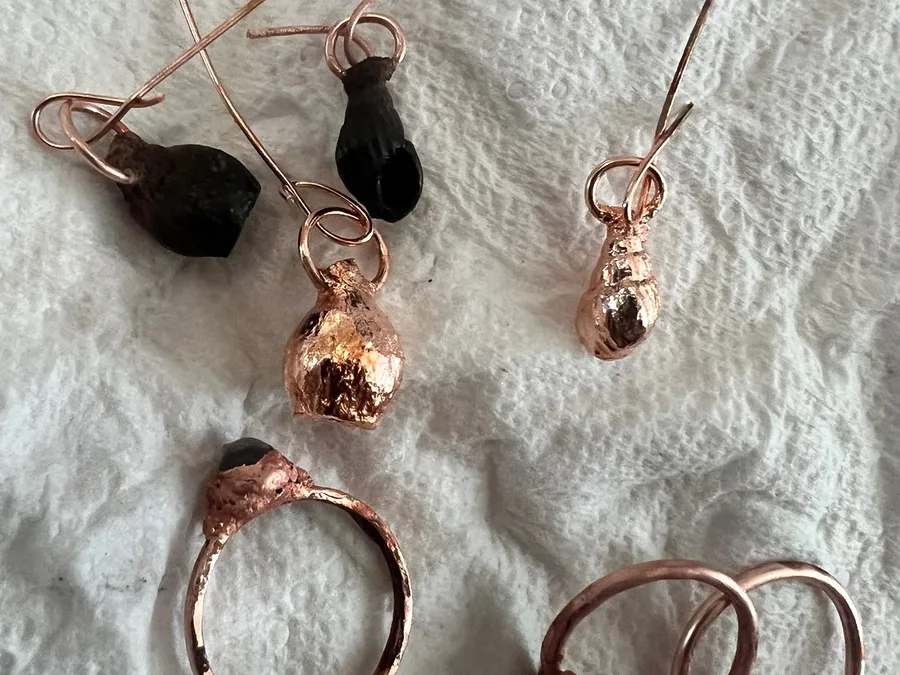 Jewellery pieces hanging in a window during the making process.